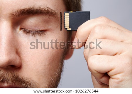 Attractive man at studio background, business concept, copy space, portrait, holding memory card, closed eyes.  Royalty-Free Stock Photo #1026276544