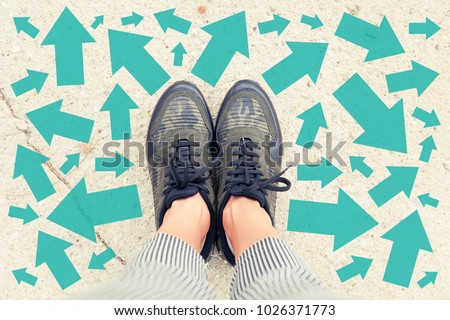 Making decisions in life / Choosing your path concept with feet and arrows showing different directions Royalty-Free Stock Photo #1026371773