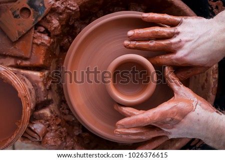 Professional potter making bowl in pottery workshop, studio. Royalty-Free Stock Photo #1026376615