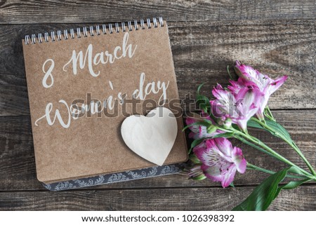 Notepad with white heart on wooden background