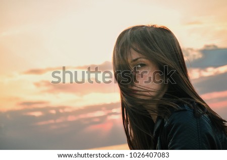 Beautiful young woman on the beach in sunrise