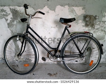 Old bicycle against a rustic wall