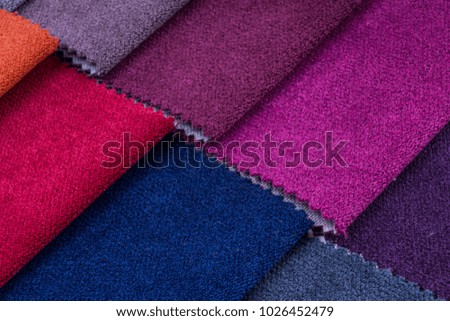 Colorful and bright fabric pattern palette texture samples as abstract textile background. Handmade, clothes and furniture decoration concept. Detailed closeup studio shot with soft selective focus
