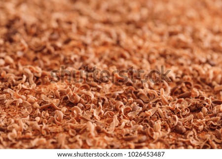 Chocolate flakes, extreme macro. Close up of fine chocolate chips and curls chopped by hand on cake texture. Best picture of tasty chocolate curls shavings. Conceptual food photo