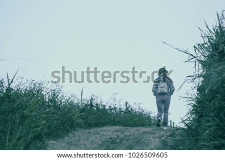 Young woman enjoying at a hill with blue sky. Sunrise in the morning. People have a trekking 

trips to a fog valley. Picture in vintage tone. 
