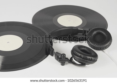 Headphones and two vinyl records. Background on the theme of music.
