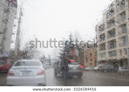 Street Bokeh Lights Out Of Focus. Rain drops on car glass. Rainy days, Blurry car silhouette