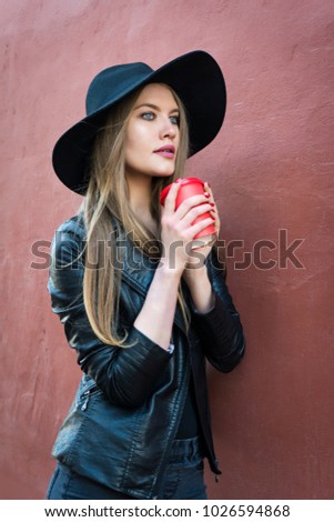 Young beautiful woman in a hat walking around the city