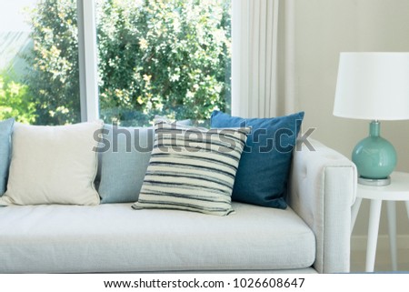 classic gray sofa and navy blue pillows by the window in living corner