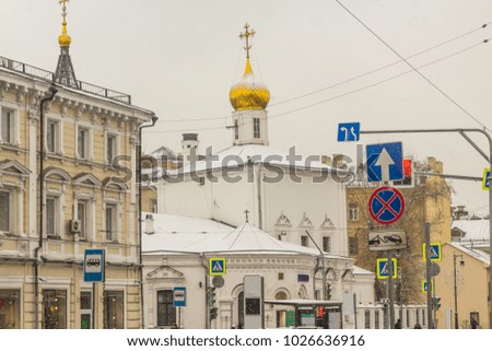 The Orthodox Church, with white walls and a golden dome,during a snowfall.An photo for the site about travel, history, religion, architecture and art.
