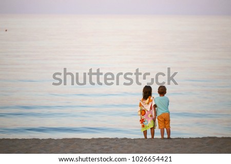 children boy and girl romance on the seashore colorful sunset