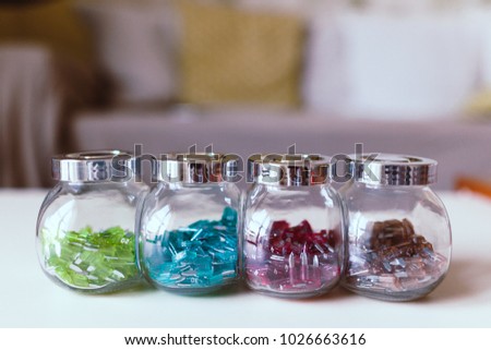 Car electric parts colorful mini fuses in kitchen spice rack on desk. Soft focus.