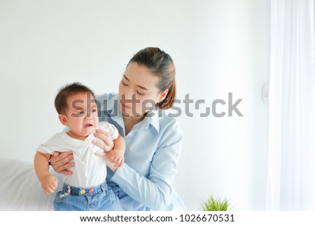 crying little boy being consoled by mother Royalty-Free Stock Photo #1026670531
