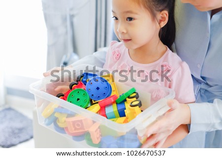 Little cute asian girl playing plastic colorful toys Keep in a box Royalty-Free Stock Photo #1026670537