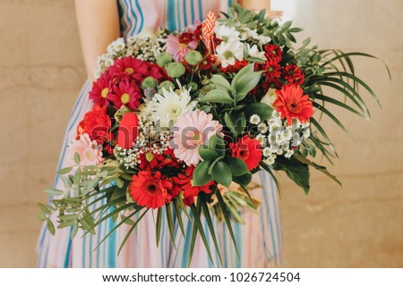 Big flower bouquet with red dahlia holding by a girl