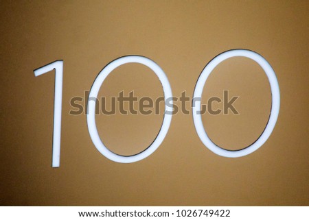 Number 100 lettering on a wall.