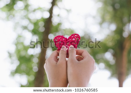 Red heart shape in the woman hands.