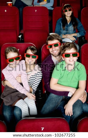 Happy family with two children watching a movie