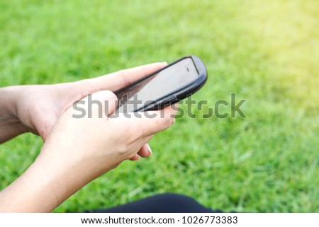 A girl browsing her smartphone after work out in the park.