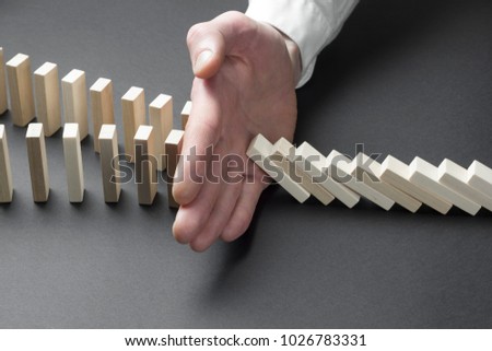 Businessman hand stop domino continuous tipping or risk. Strategy in business.