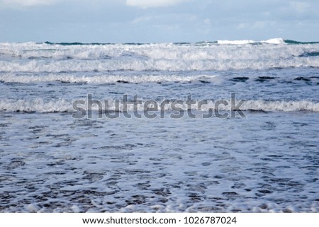 Waves come to shore on a sandy beach 