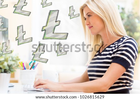Litecoin with happy young woman sitting at her desk in front of the computer