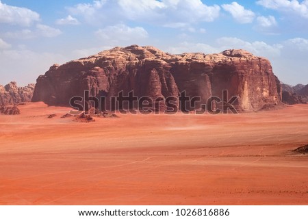 Red mountains of the canyon of Wadi Rum desert in Jordan. Wadi Rum also known as The Valley of the Moon is a valley cut into the sandstone and granite rock in southern Jordan to the east of Aqaba. Royalty-Free Stock Photo #1026816886