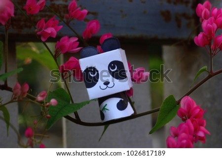 Panda 3d  paper craft on pink flower branch.