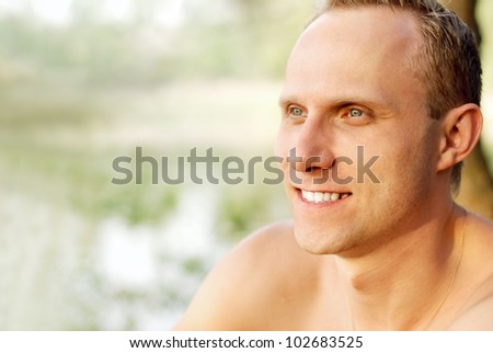 Happy young man portrait near the river coast