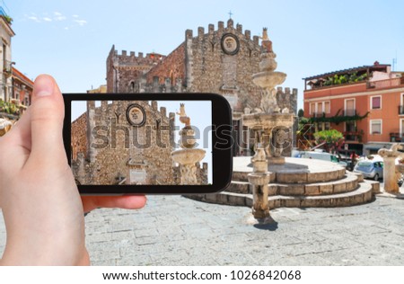 travel concept - tourist photographs Piazza Del Duomo and Duomo di Taormina (Cathedral San Nicolo di Bari) in Taormina city in Sicily Italy in summer on smartphone