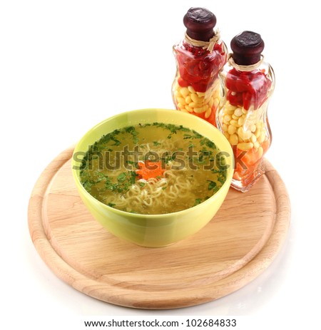 Tasty chicken stock with noodles on wooden round board isolated on white