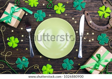 Festive table setting for St.Patrick's day with cutlery and lucky symbols on wooden table. Copy spase, top view.