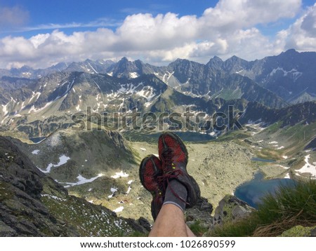 
Man relaxing with view from Kozi wierch in the Tatra mountains. Dolina pieciu stawow. Valley of Five Lakes
