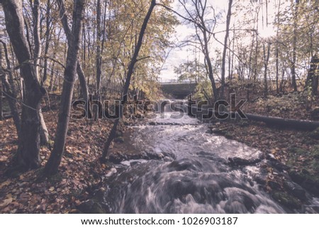 mountain river in autumn with stream and high water in forest - vintage retro effect