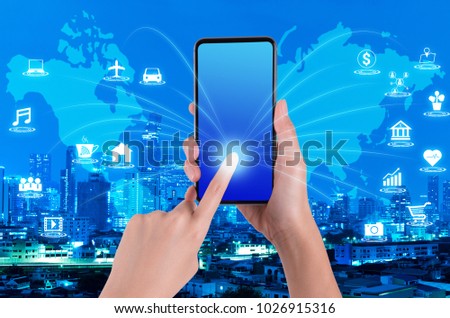 woman hand using smartphone on internet of things and world map with blue night modern city background