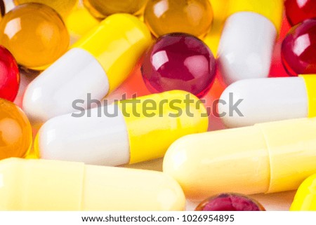 Colorful vitamin pills, medicine tablets and capsules on an abstract white background. Healthcare, medical and pharmaceutical concept. Detailed closeup studio shot with soft selective focus.