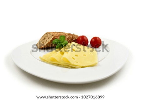 Slice of cheese with garnish stock images. Piece of cheese with tomatoes and basil. Cheese isolated on a white background. Healthy snack images