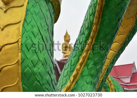 Sittiing Buddha Statue through giant green concrete Naga statue
