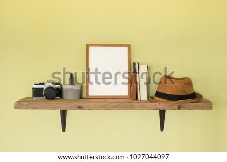 Mock up frame photo on wooden shelf. Lifestyle hipster decoration at home and travel concept