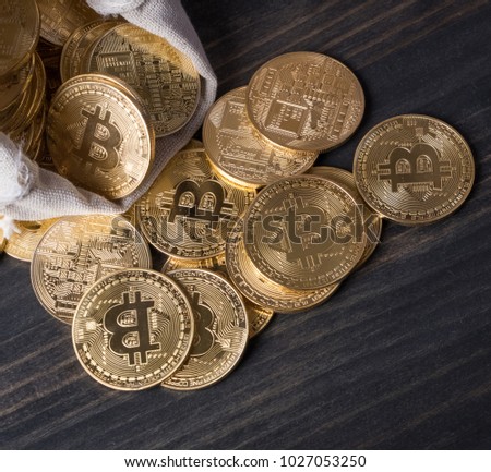 Bitcoin in money pouch on wooden table top