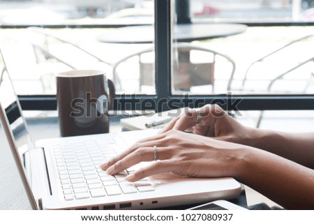 Woman's hand using laptop computer and mobile device in cafe, Technology and lifestyle concept