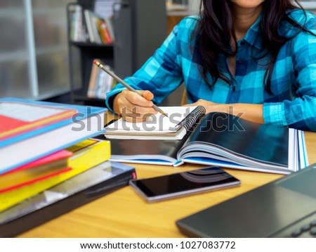 Young student (Freelancer) woman studying & learning with stack of books while writing on notebook / Education & Freelance work, Business people concept