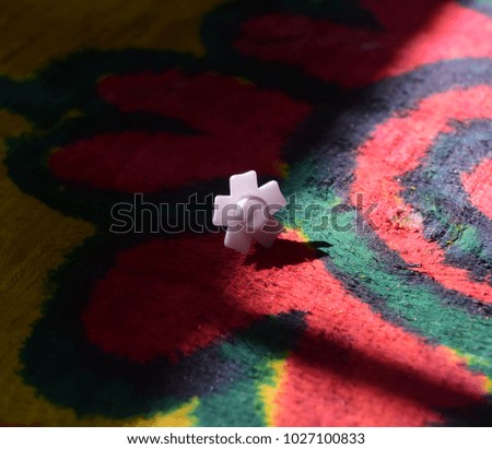 White coloured unique object on top of a colourful wooden surface stock photograph