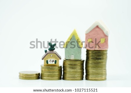 increasing stack of coins and lovely house use as family saving money , investent and financial concept.