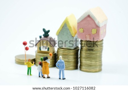 Miniature people: Family standing infront to seeing on an increasing stack of coins and lovely house use as family and financial concept.