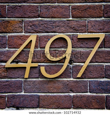three dimensional house number four hundred and ninety-seven on a brick wall