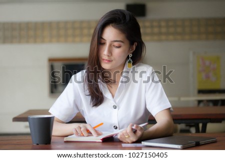 Portrait of thai adult student university uniform beautiful girl Write book
