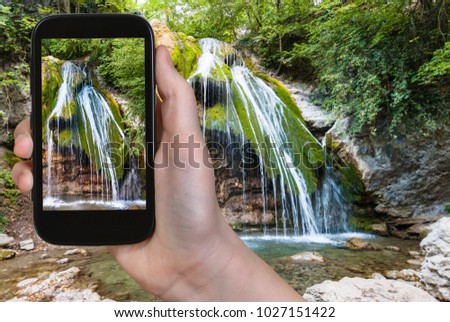 travel concept - tourist photographs Ulu-Uzen river with Djur-djur waterfall in Haphal Gorge of Habhal Hydrological Reserve natural park in Crimean Mountains in Crimea in september on smartphone