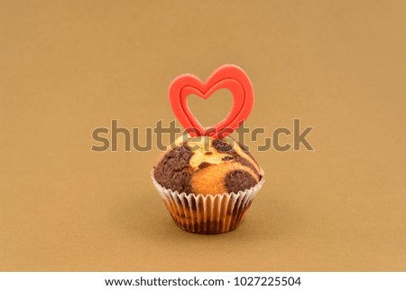 Muffin with heart stock images. Chocolate muffin with heart on a brown background. Sweet valentine pastry. Valentines Day concept
