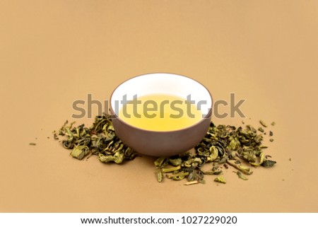 Cup of green tea stock images. Green tea on a brown background. Loose green tea. Chinese tea cup